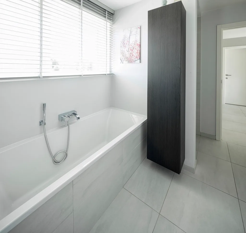 Minimal white bath with full-height wall tile