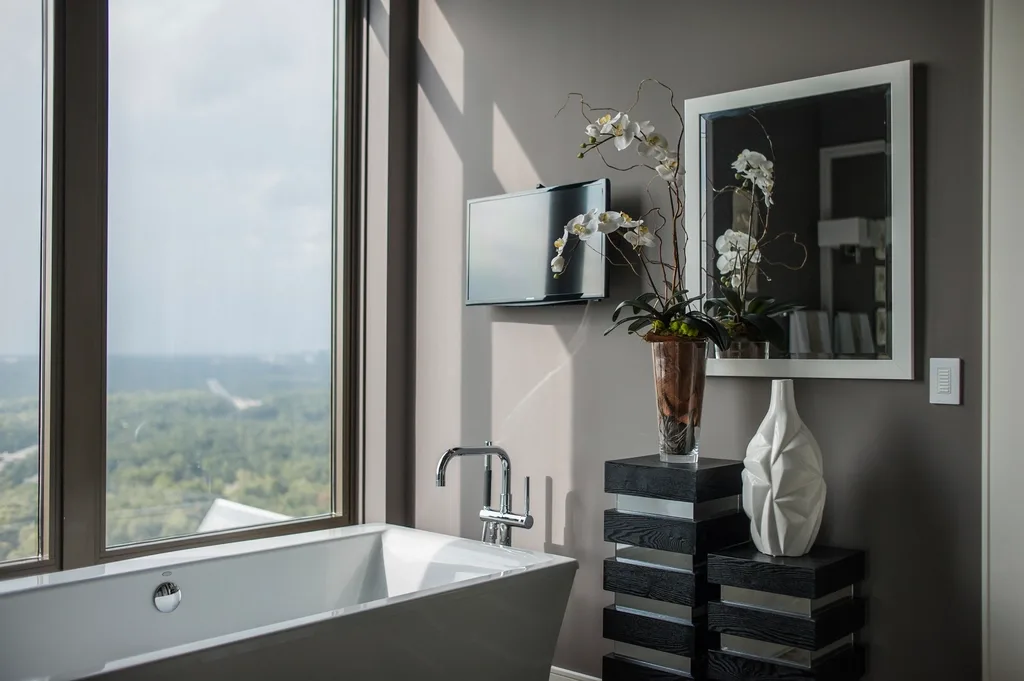 Freestanding bath beside a full-height window